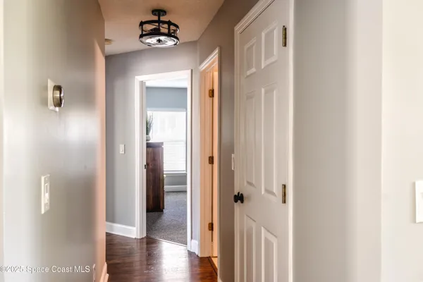 a view of a hallway with wooden floor