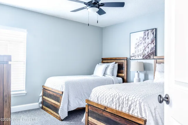 a bedroom with two beds and painting on the wall