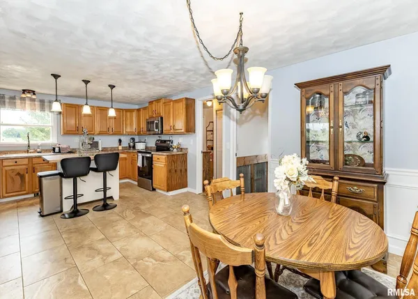 a kitchen with stainless steel appliances kitchen island granite countertop a sink refrigerator and cabinets