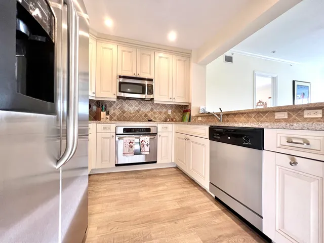 a kitchen with stainless steel appliances granite countertop a stove a sink and a refrigerator