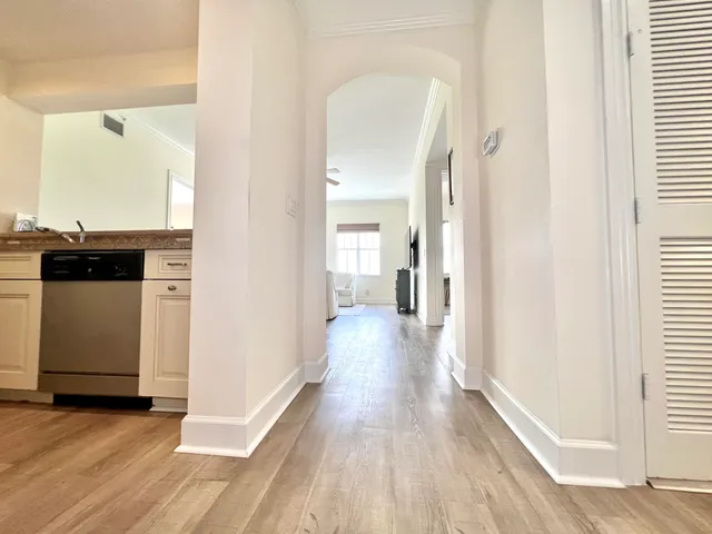 a view of a hallway with wooden floor and a living room