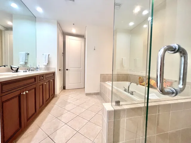 a bathroom with a double vanity sink mirror and bathtub