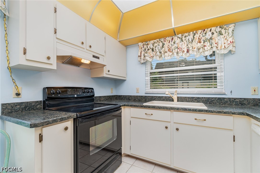 10615 Roxbury Court Lehigh Acres, FL 33936 - Photo 13 of 33 a kitchen with granite countertop a sink a stove and cabinets