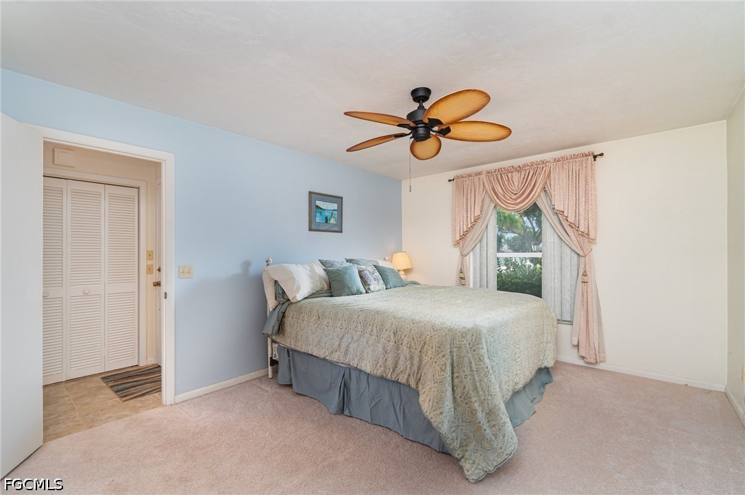 10615 Roxbury Court Lehigh Acres, FL 33936 - Photo 15 of 33 a bedroom with a bed a window and a chandelier