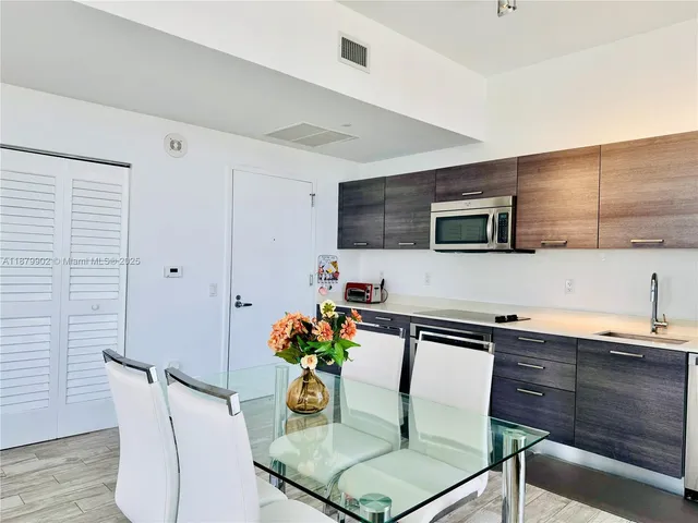 a living room with furniture kitchen view and a potted plant