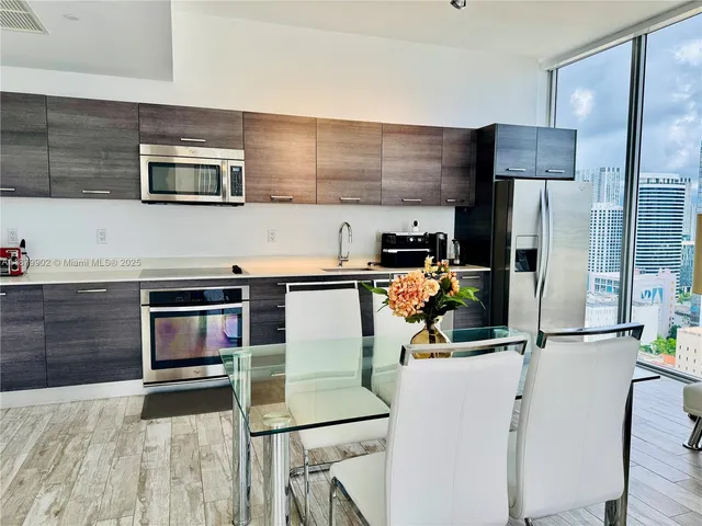 a kitchen with stainless steel appliances kitchen island granite countertop a refrigerator and a stove top oven