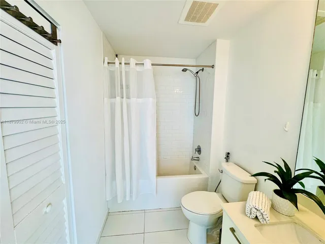a bathroom with a toilet and a shower curtain