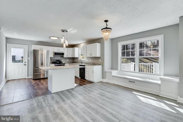 a kitchen with granite countertop a sink stove and cabinets