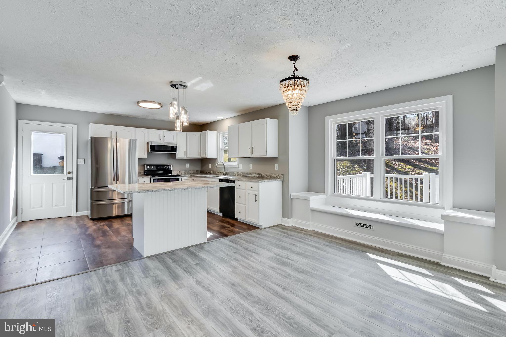648 Santa Fe Trail Lusby, MD 20657 - Photo 15 of 58 a kitchen with granite countertop a refrigerator and wooden floor