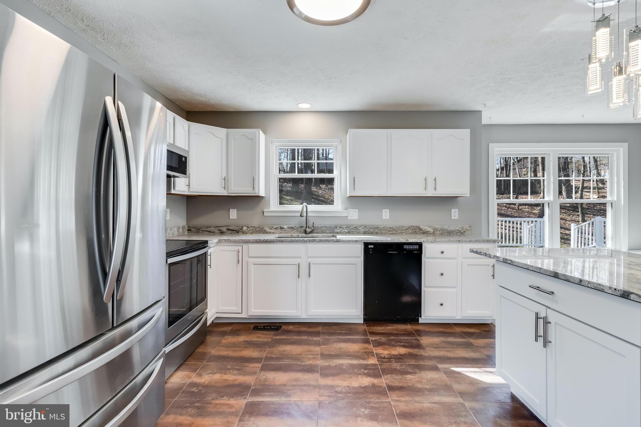 648 Santa Fe Trail Lusby, MD 20657 - Photo 17 of 58 a kitchen with granite countertop a refrigerator stove top oven and sink