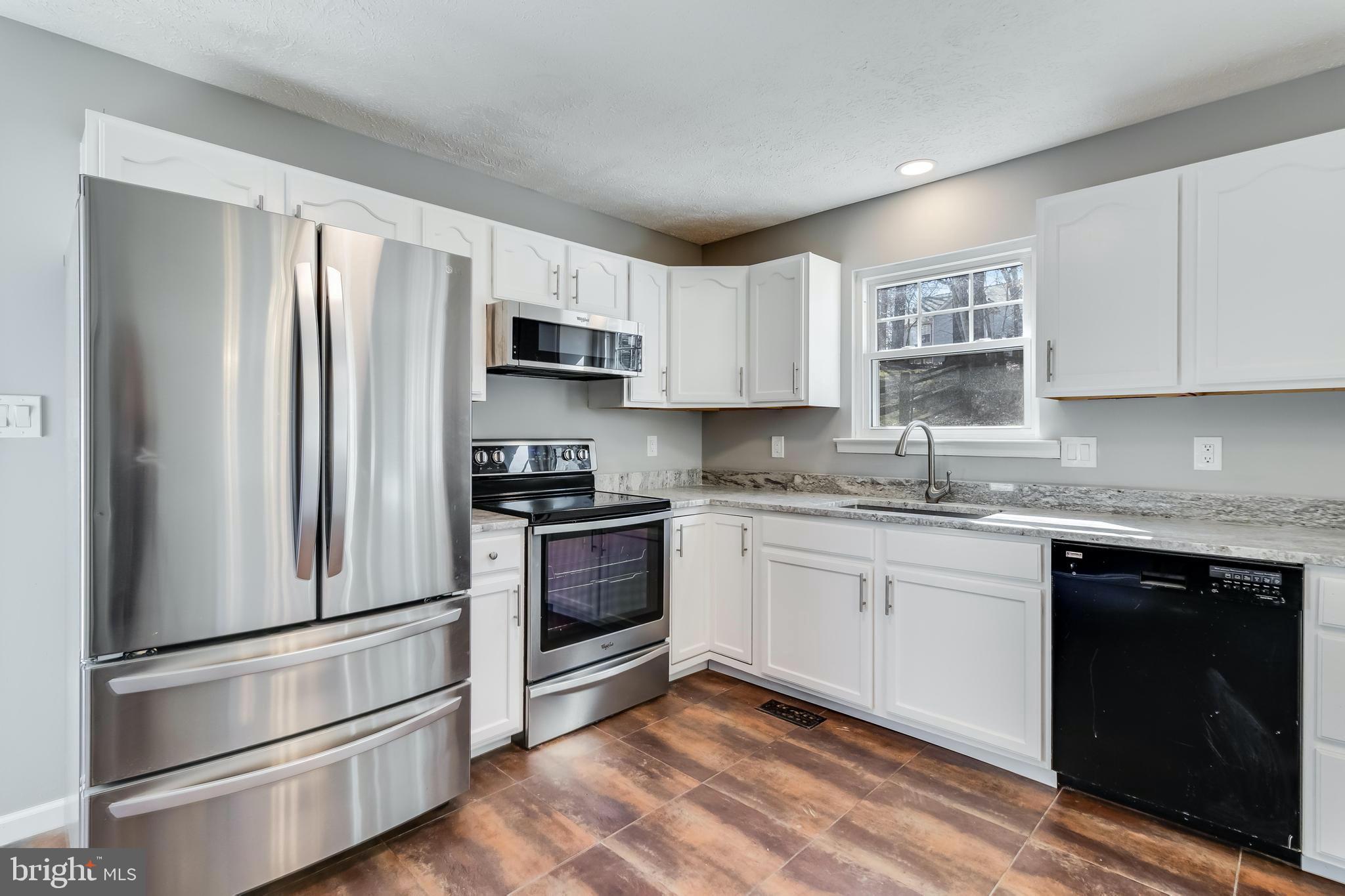 648 Santa Fe Trail Lusby, MD 20657 - Photo 18 of 58 a kitchen with granite countertop white cabinets and stainless steel appliances