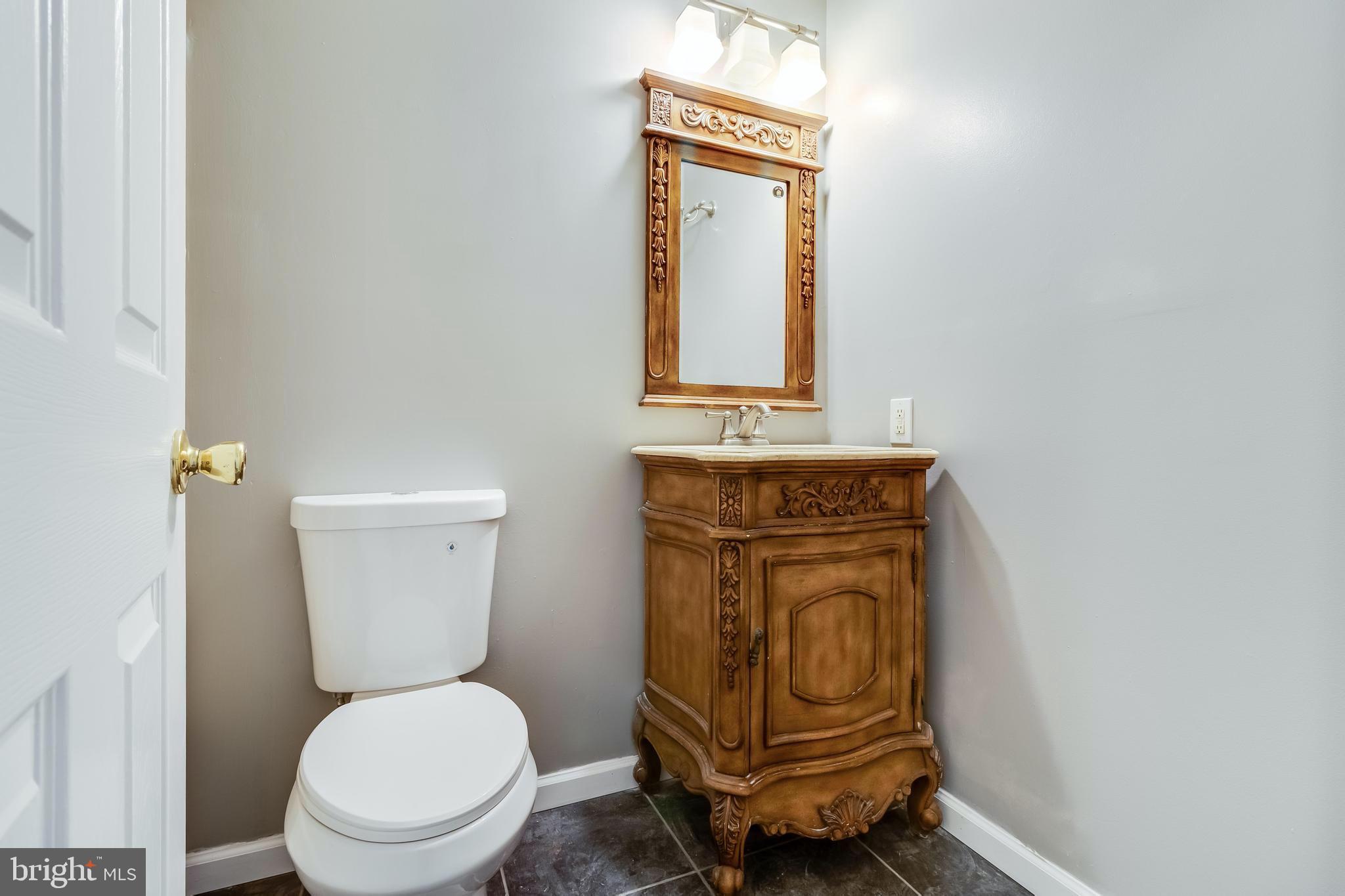 648 Santa Fe Trail Lusby, MD 20657 - Photo 23 of 58 a bathroom with a toilet a sink and mirror