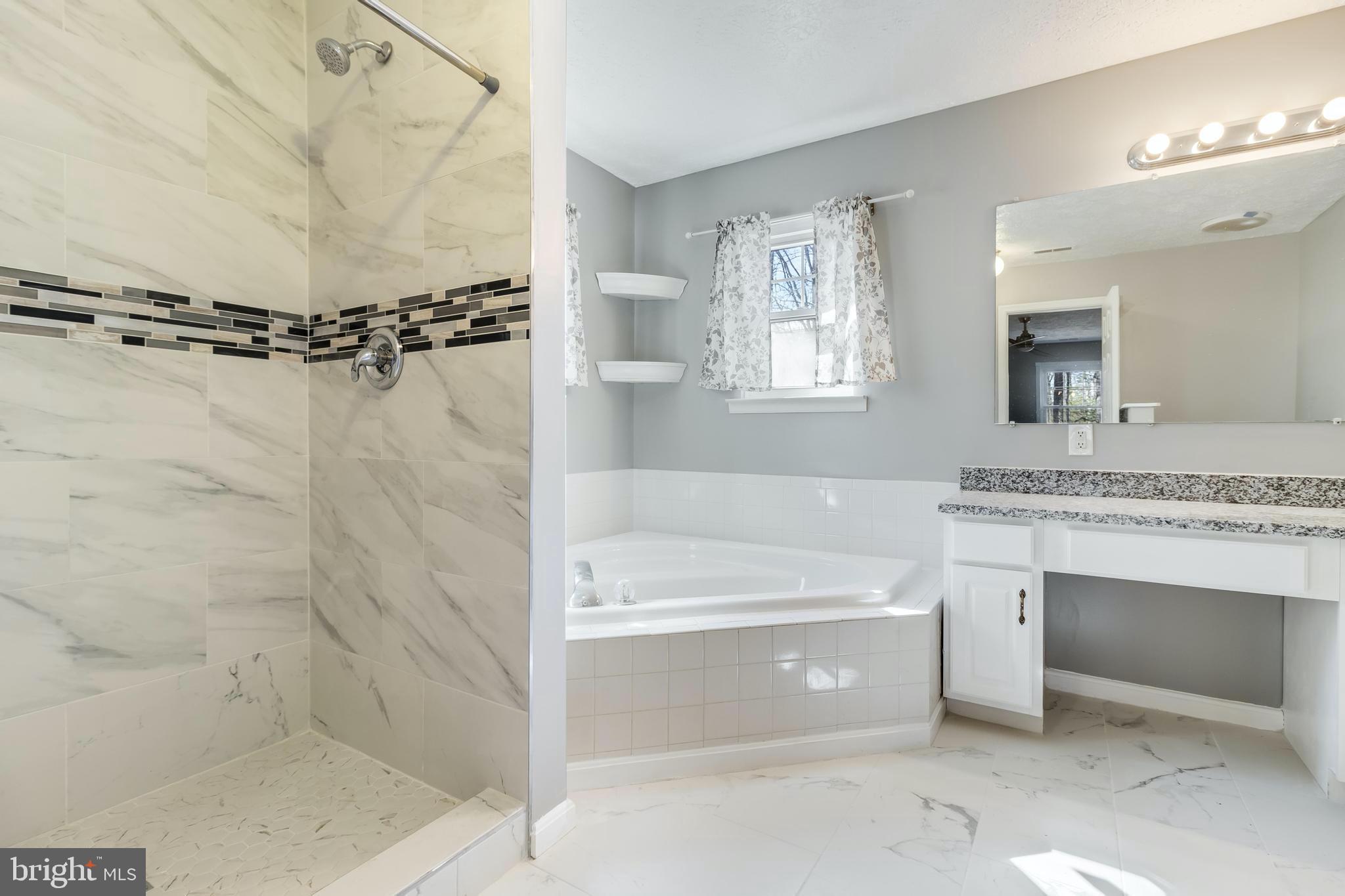 648 Santa Fe Trail Lusby, MD 20657 - Photo 25 of 58 a bathroom with a tub a sink and mirrors