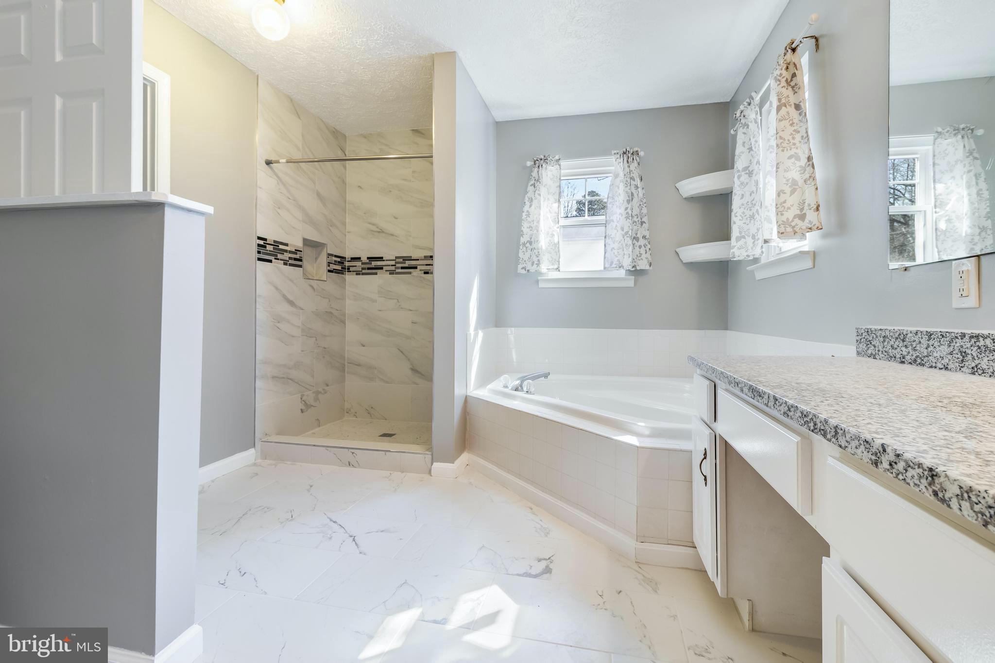 648 Santa Fe Trail Lusby, MD 20657 - Photo 29 of 58 a spacious bathroom with a granite countertop tub a sink and a shower