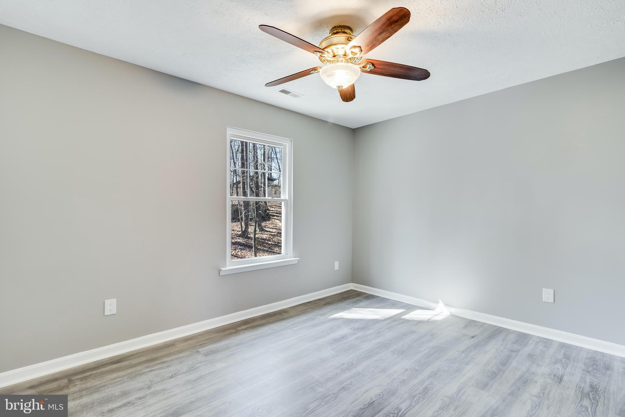 648 Santa Fe Trail Lusby, MD 20657 - Photo 32 of 58 an empty room with a window and a fan