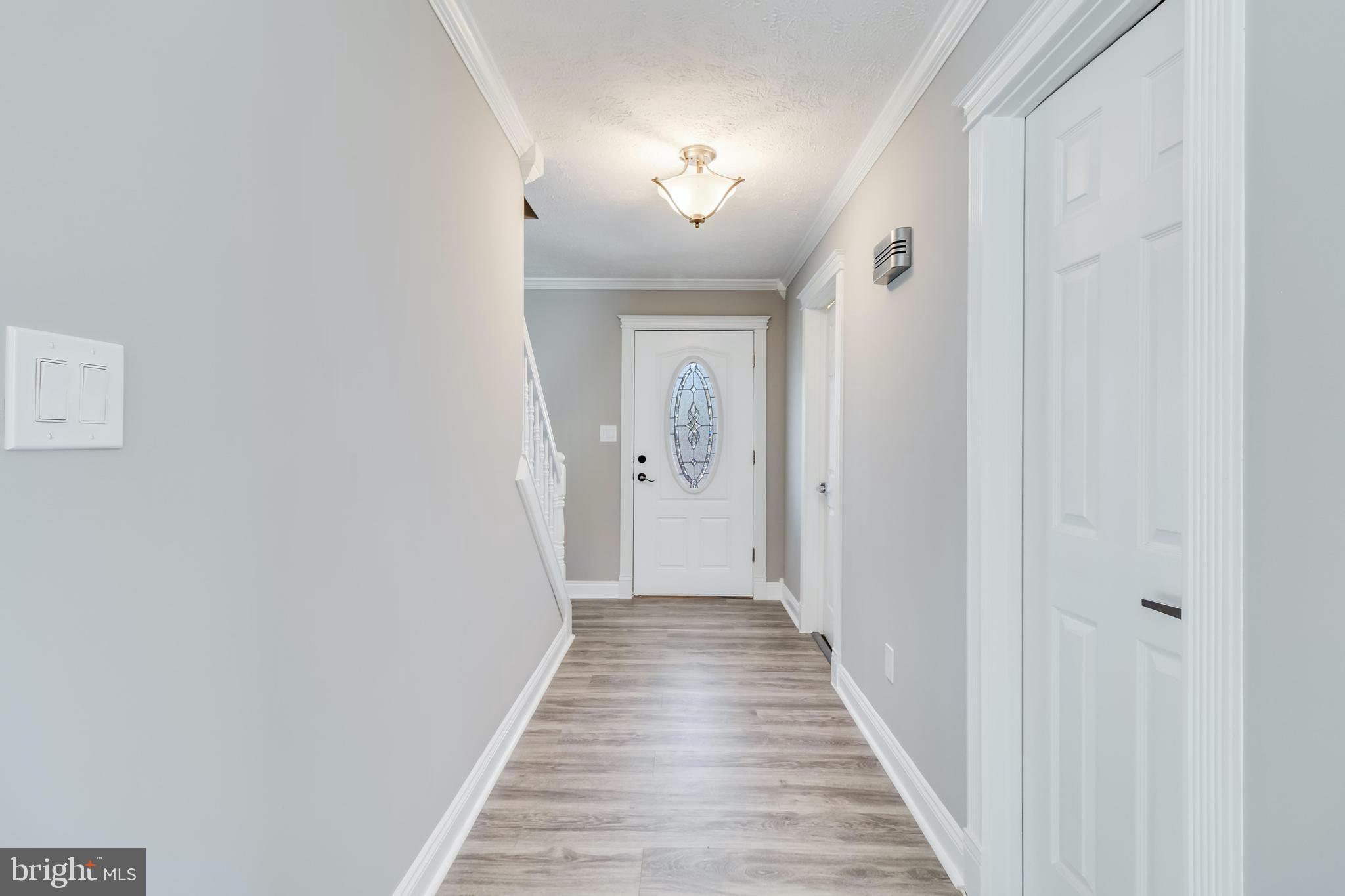 648 Santa Fe Trail Lusby, MD 20657 - Photo 5 of 58 a view of a hallway with wooden floor and a staircase