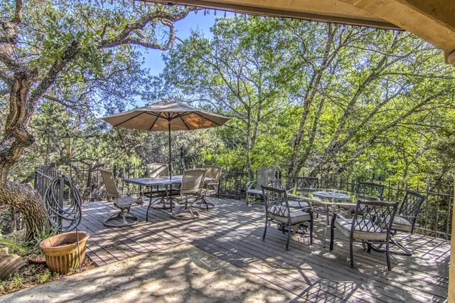 a view of a patio with table and chairs under an umbrella