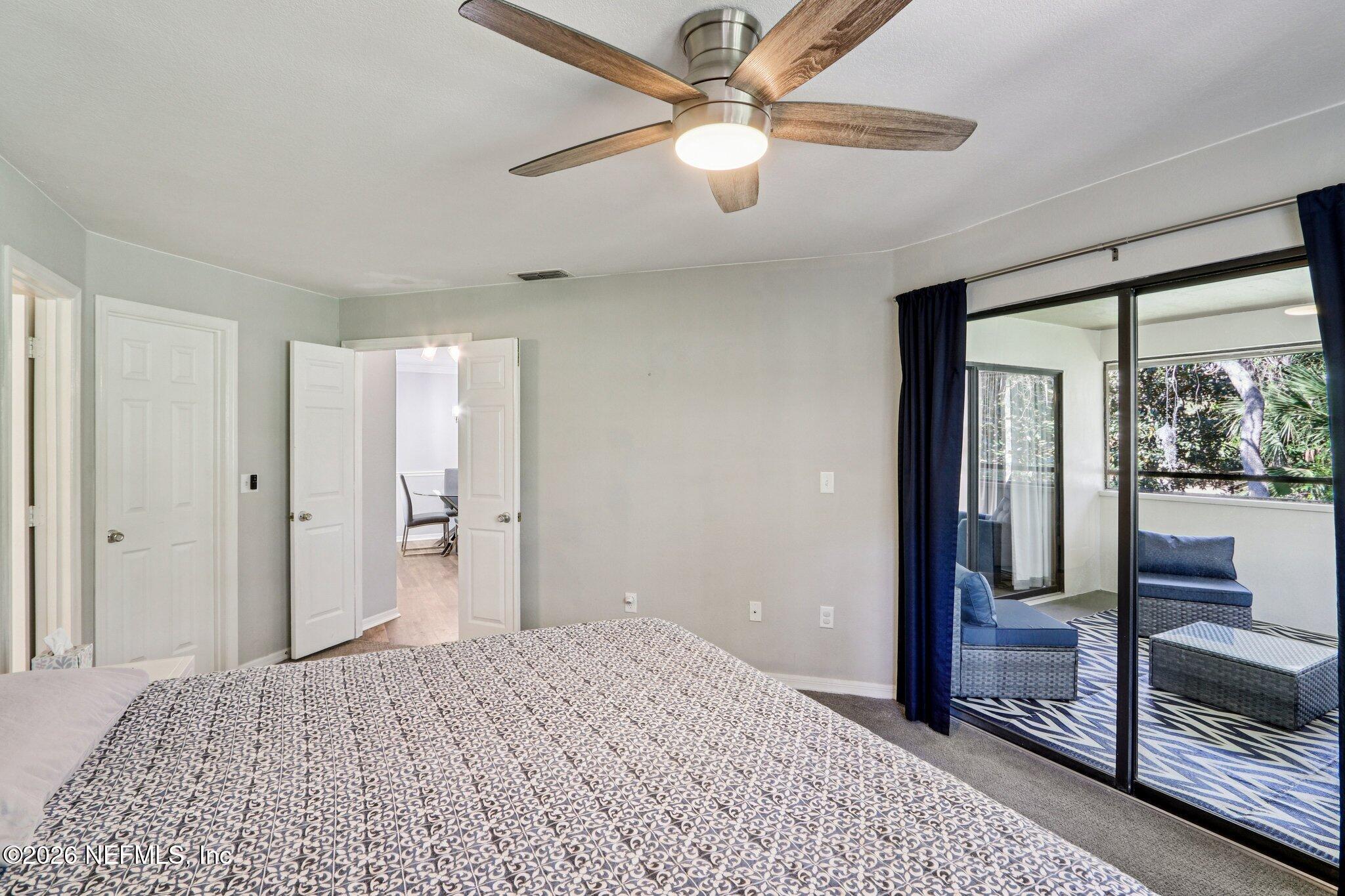 10150 Belle Rive Boulevard, Unit 102 Jacksonville, FL 32256 - Photo 11 of 33 a bedroom with a bed and a chandelier