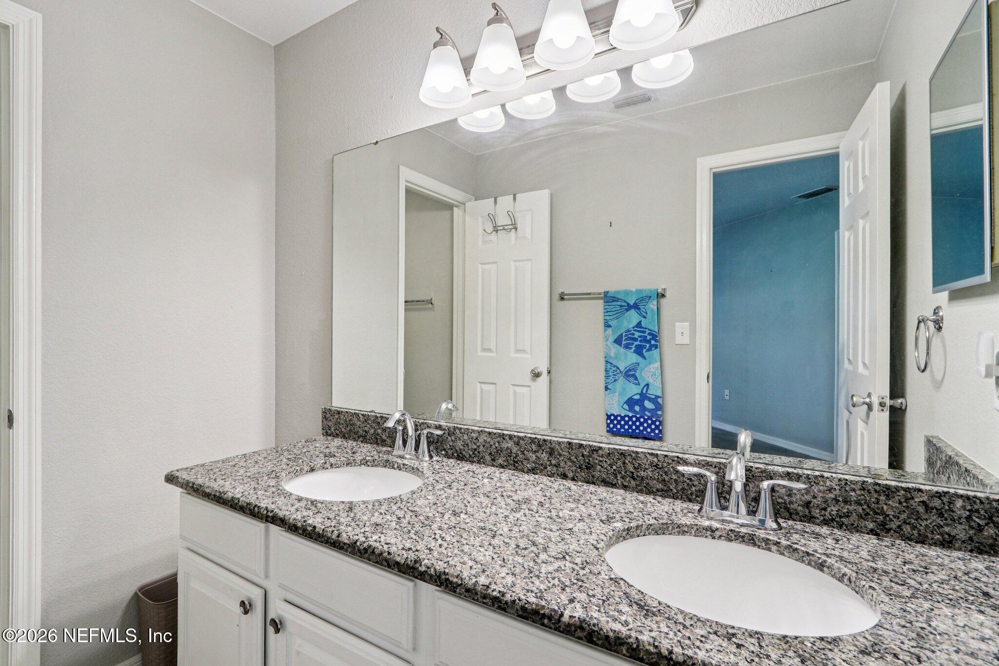 10150 Belle Rive Boulevard, Unit 102 Jacksonville, FL 32256 - Photo 12 of 33 a bathroom with a granite countertop double vanity and a mirror