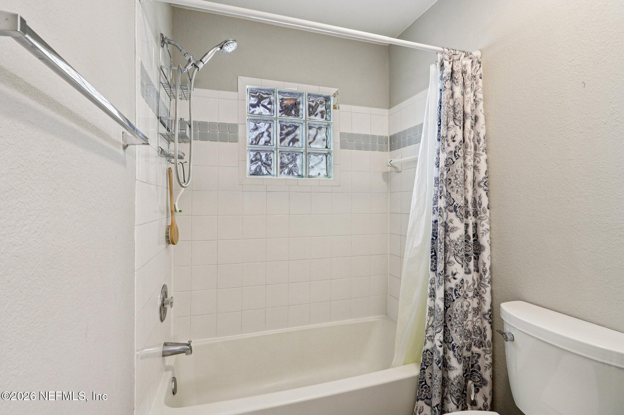 10150 Belle Rive Boulevard, Unit 102 Jacksonville, FL 32256 - Photo 13 of 33 a bathroom with a shower a toilet and a shower