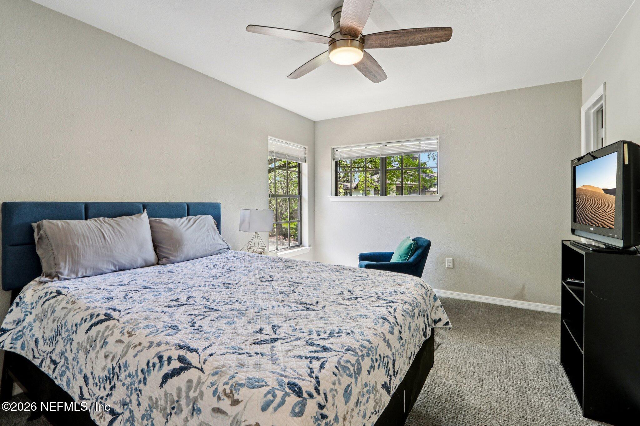 10150 Belle Rive Boulevard, Unit 102 Jacksonville, FL 32256 - Photo 14 of 33 a bedroom with a large bed and a tv