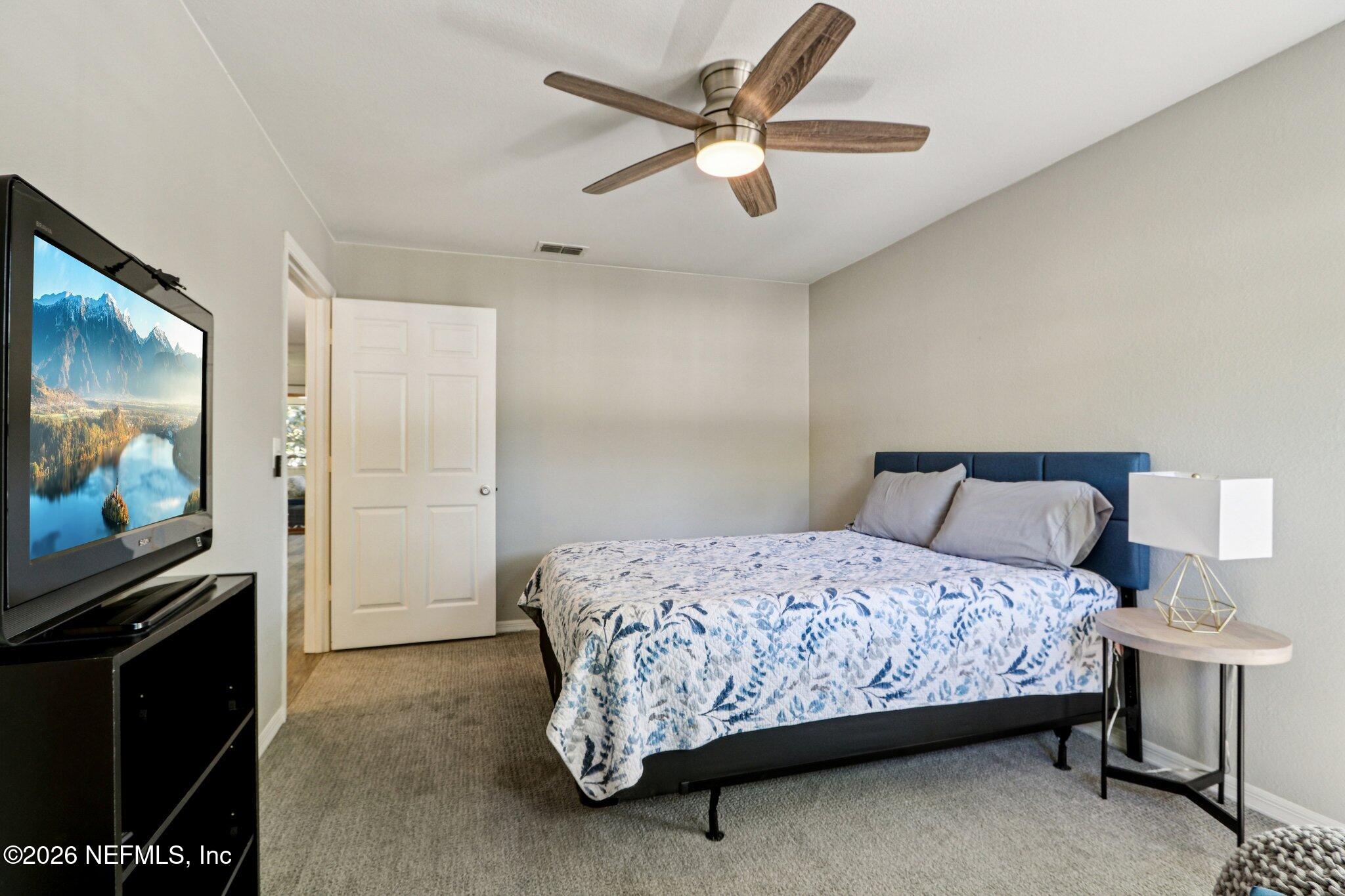 10150 Belle Rive Boulevard, Unit 102 Jacksonville, FL 32256 - Photo 15 of 33 a bedroom with a bed and a flat screen tv