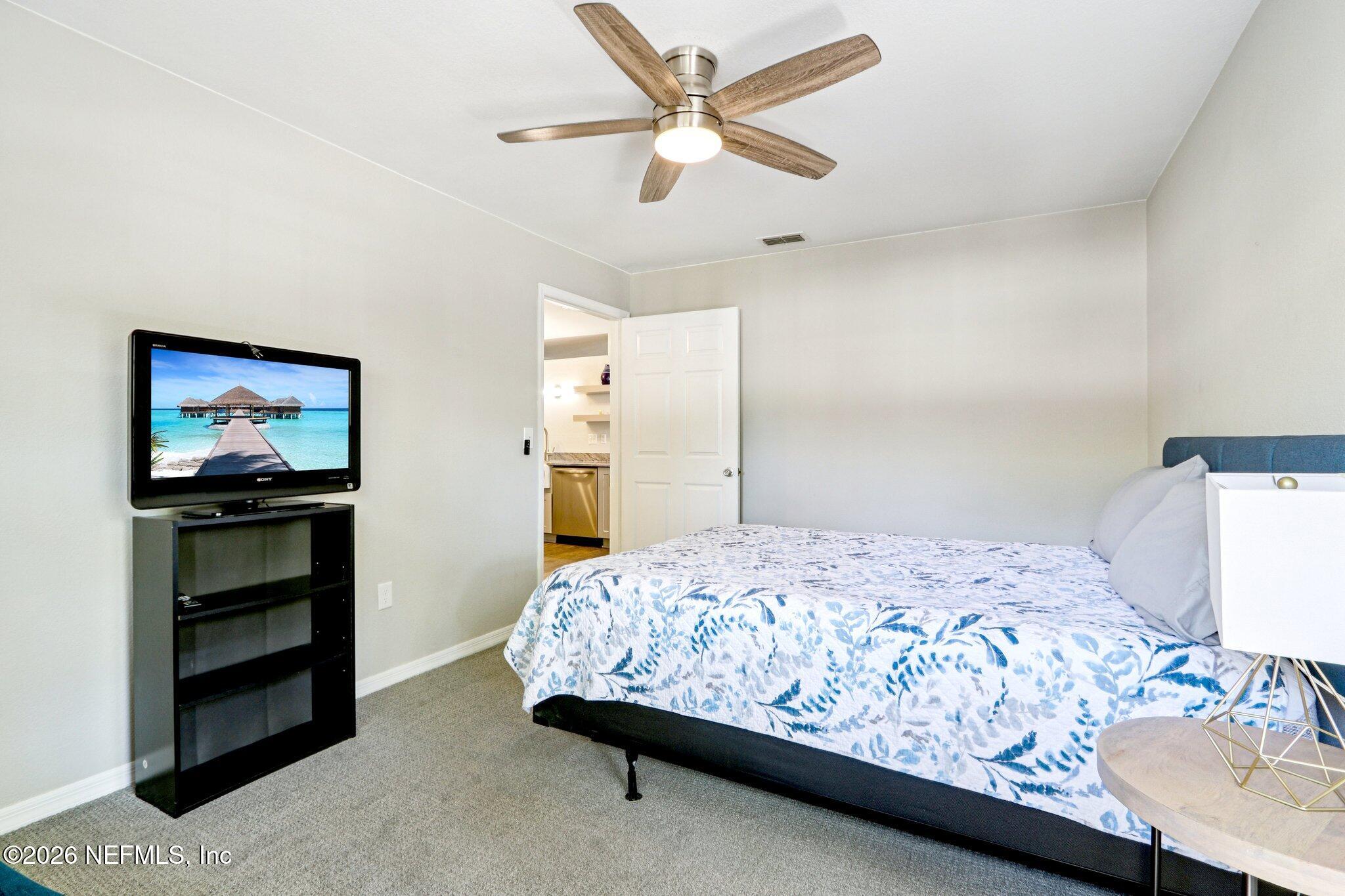 10150 Belle Rive Boulevard, Unit 102 Jacksonville, FL 32256 - Photo 16 of 33 a bedroom with a bed and a flat screen tv