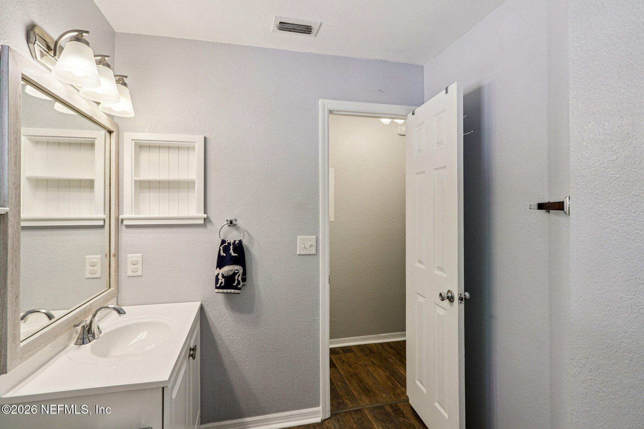 10150 Belle Rive Boulevard, Unit 102 Jacksonville, FL 32256 - Photo 17 of 33 a bathroom with a sink and mirror