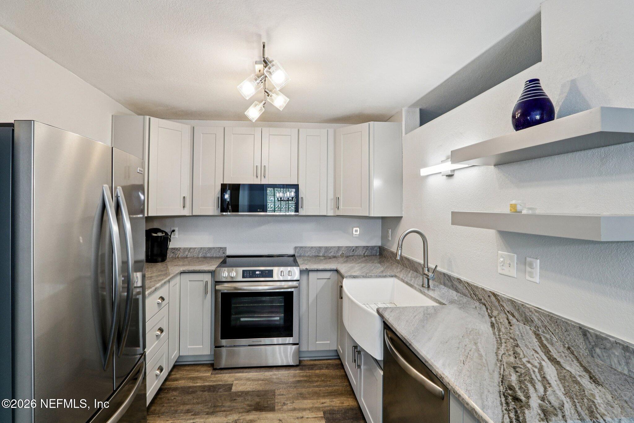 10150 Belle Rive Boulevard, Unit 102 Jacksonville, FL 32256 - Photo 9 of 33 a kitchen with a sink stove and refrigerator