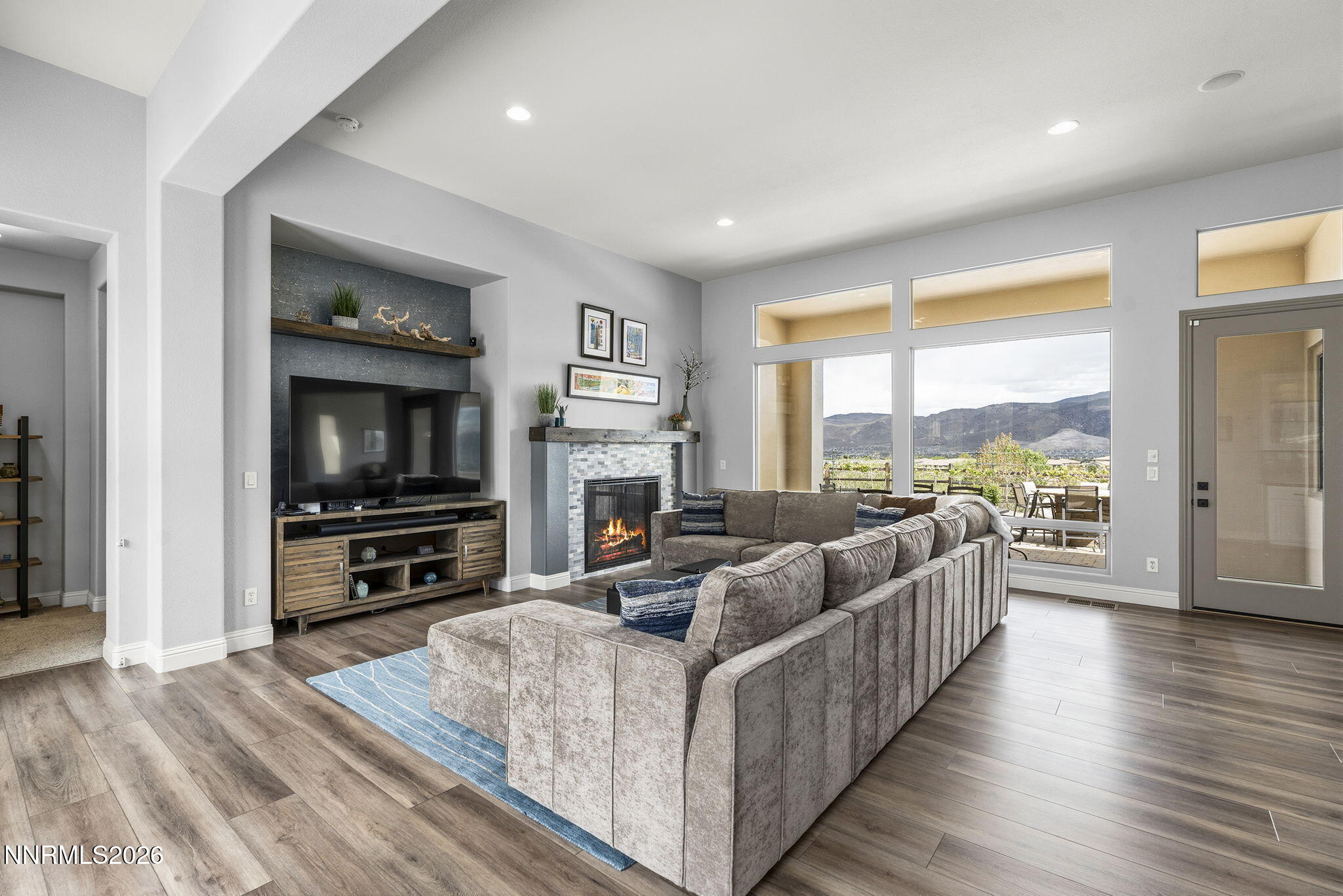 13340 Damonte View Lane Reno, NV 89511 - Photo 6 of 44 a living room with furniture a flat screen tv and a floor to ceiling window