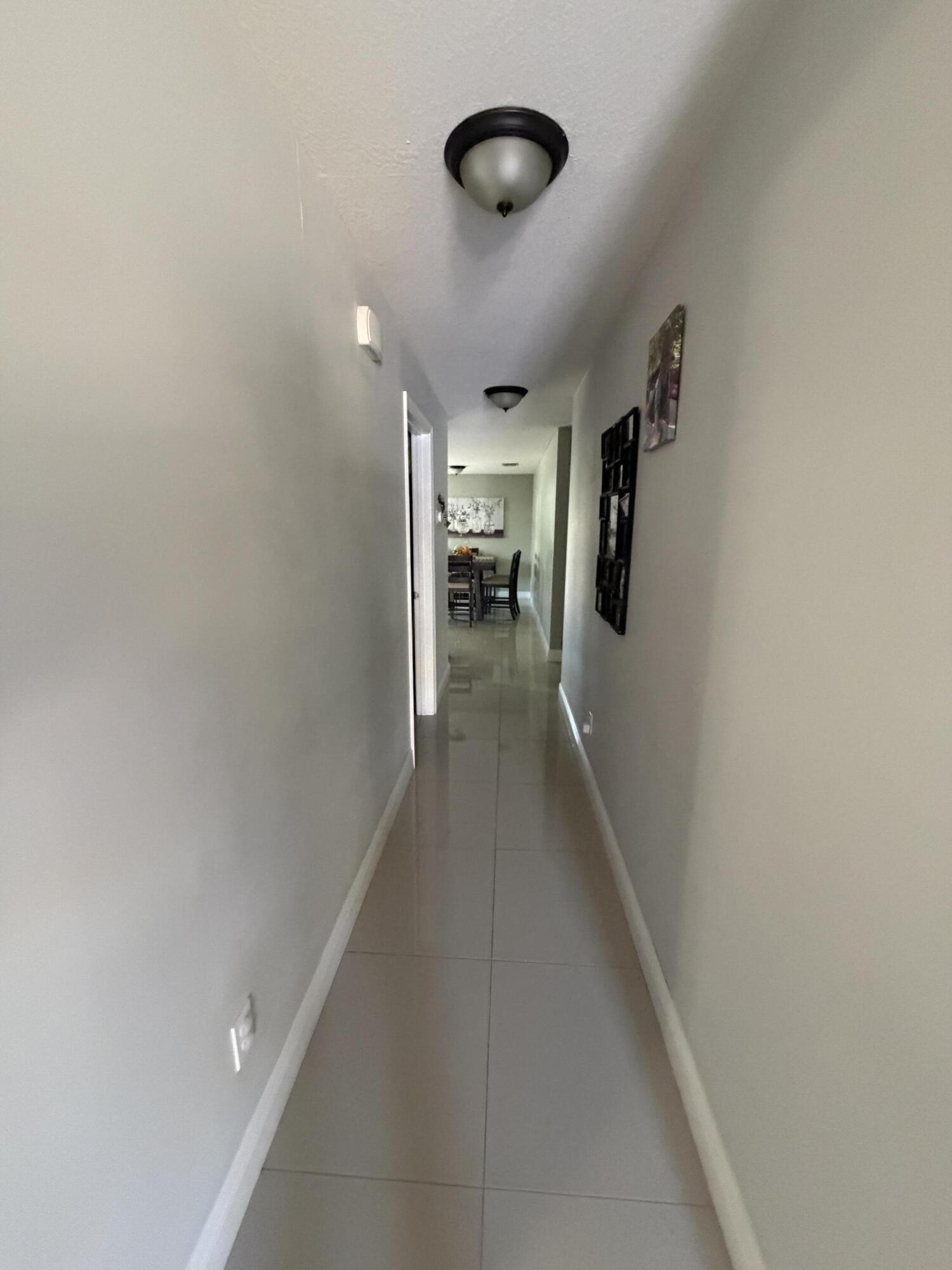 5928 Papaya Road Royal Palm Estates, FL 33413 - Photo 3 of 12 a view of a hallway with wooden floor and staircase