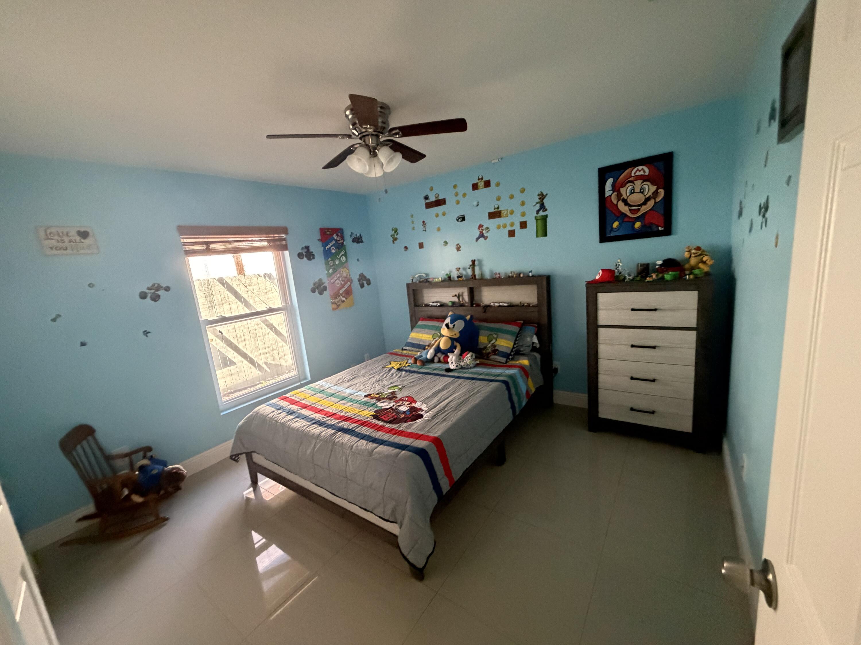 5928 Papaya Road Royal Palm Estates, FL 33413 - Photo 8 of 12 a bedroom with a bed and a chandelier