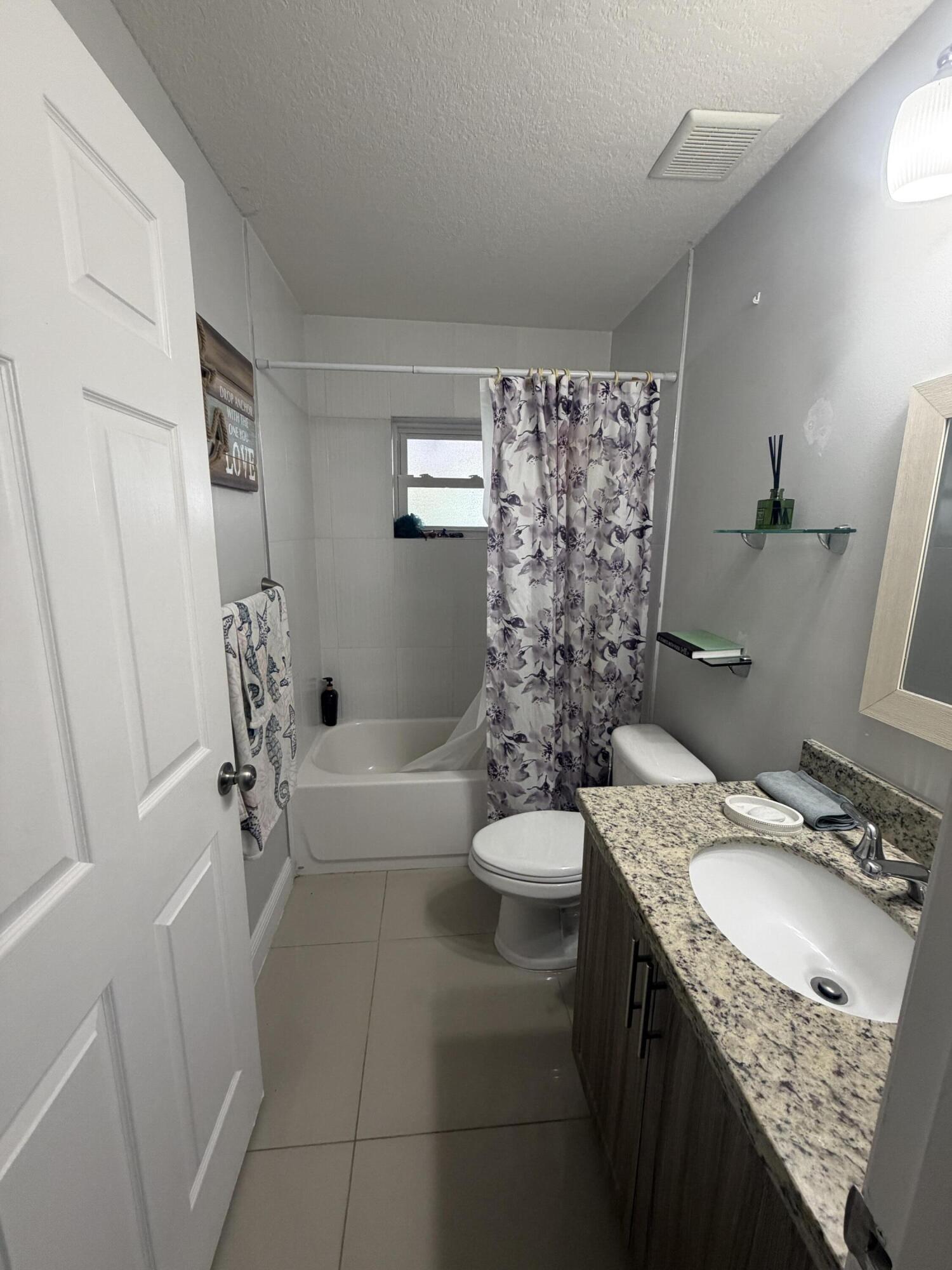 5928 Papaya Road Royal Palm Estates, FL 33413 - Photo 9 of 12 a bathroom with a granite countertop sink toilet and shower