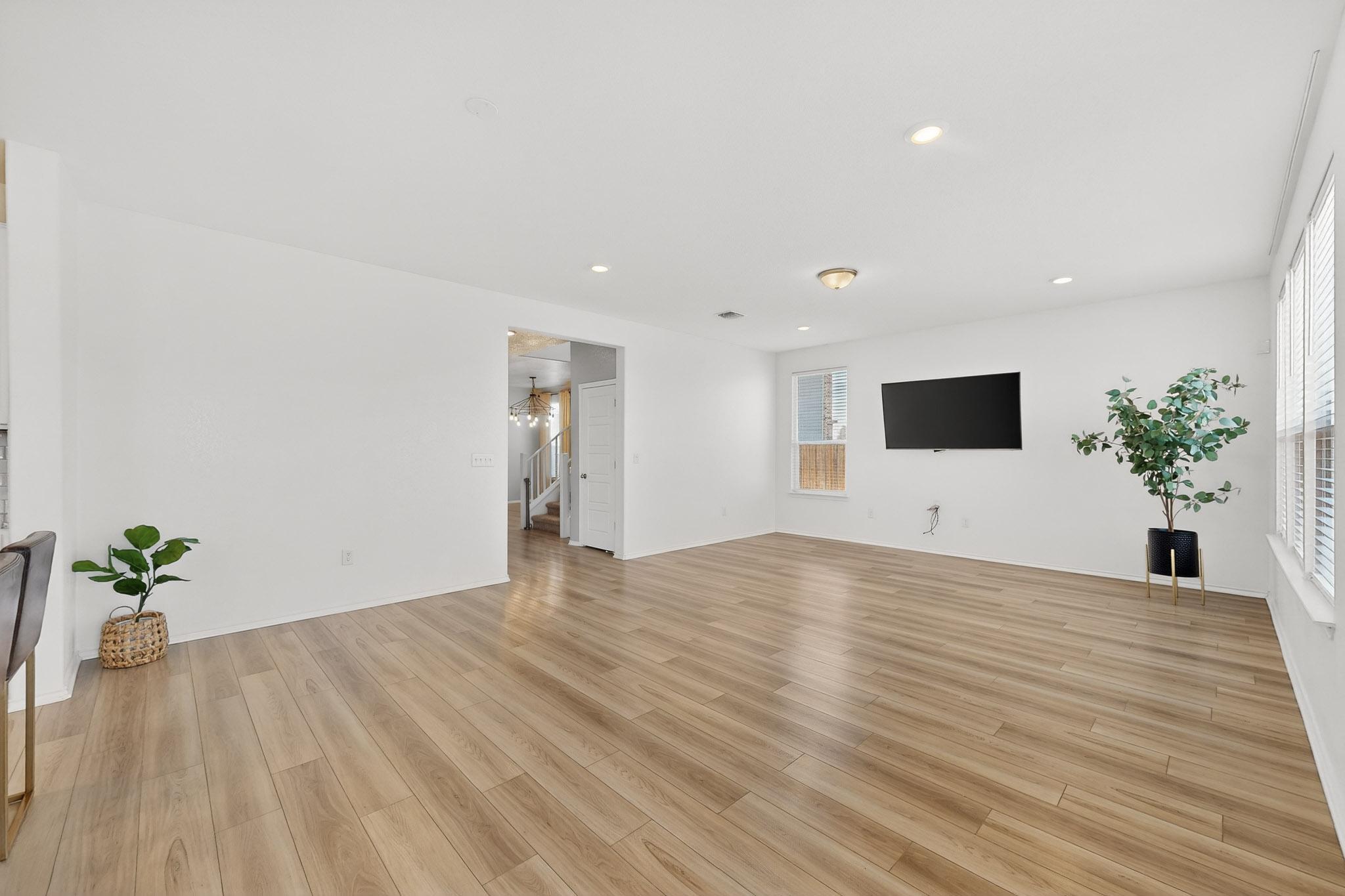 14513 Booted Eagle Pass Elgin, TX 78621 - Photo 12 of 34 a view of an empty room with wooden floor and a potted plant
