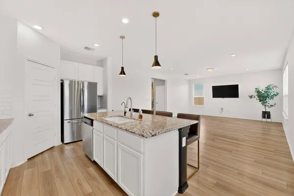 a kitchen with stainless steel appliances granite countertop a sink a refrigerator and a stove