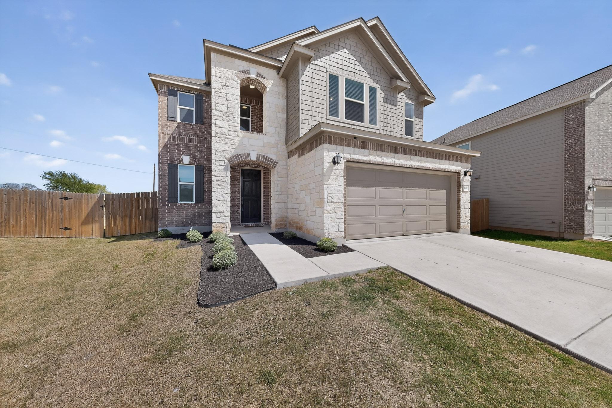 14513 Booted Eagle Pass Elgin, TX 78621 - Photo 2 of 34 a front view of a house with a yard and garage