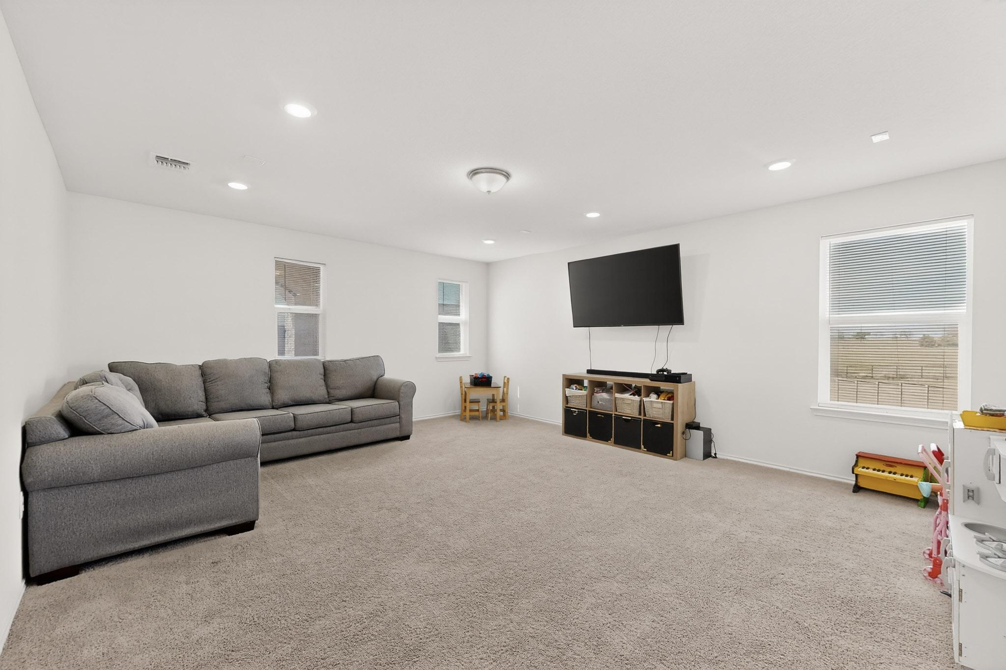 14513 Booted Eagle Pass Elgin, TX 78621 - Photo 21 of 34 a living room with furniture and a flat screen tv