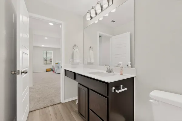 a bathroom with a sink mirror and toilet