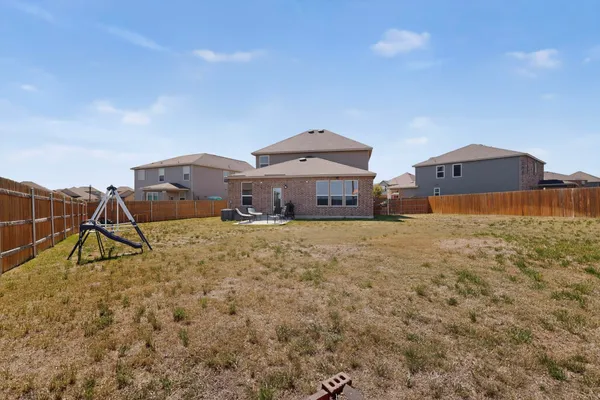 a front view of a house with a yard and a pond