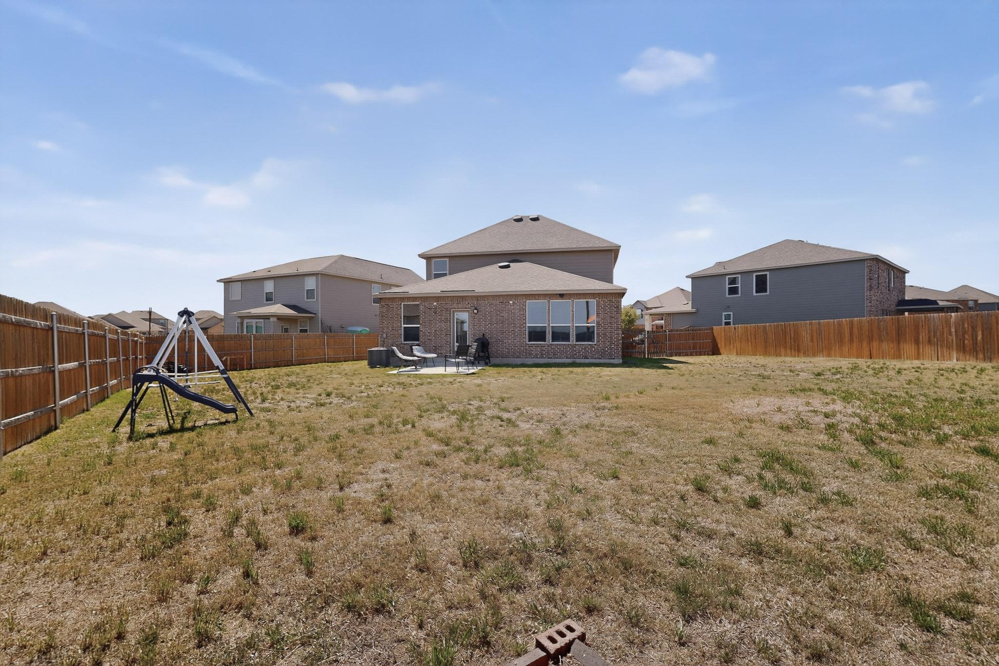 14513 Booted Eagle Pass Elgin, TX 78621 - Photo 30 of 34 a front view of a house with a yard and a pond