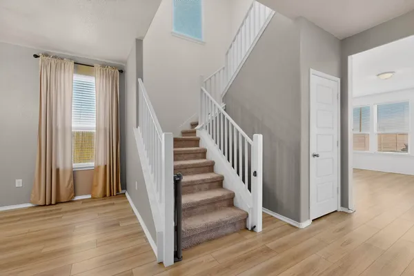 a view of a hallway with wooden floor and entryway