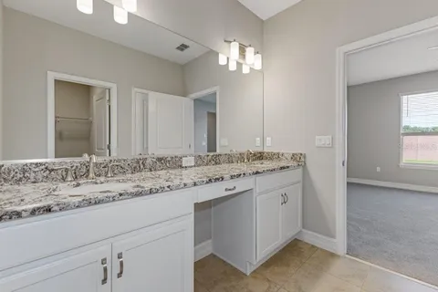 a bathroom with a granite countertop sink and a mirror