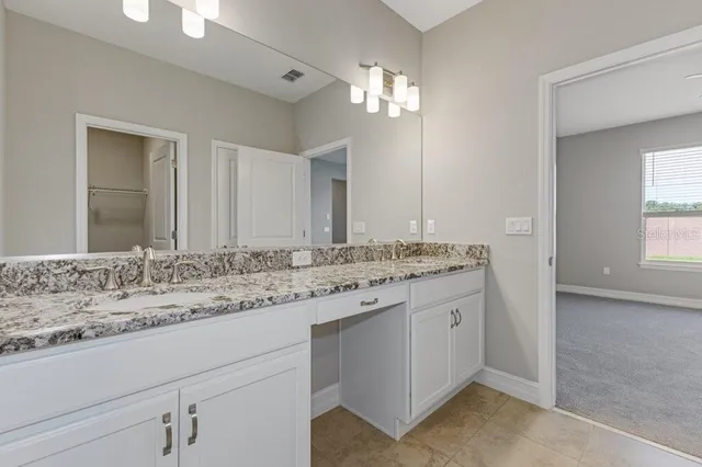 a bathroom with a granite countertop sink and a mirror