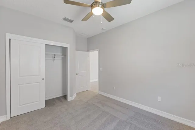 an empty room with chandelier fan