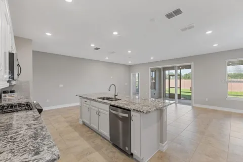 a kitchen with stainless steel appliances granite countertop a sink and a stove