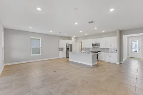 a view of kitchen with white cabinets and counter space