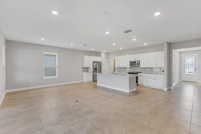a view of kitchen with white cabinets and counter space