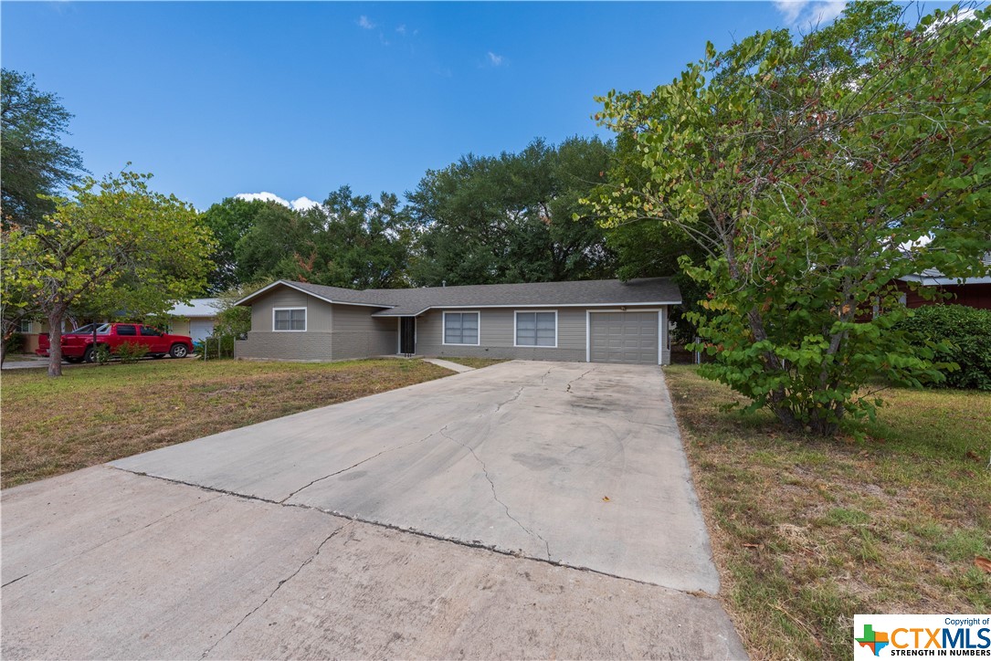 a front view of a house with a yard and trees