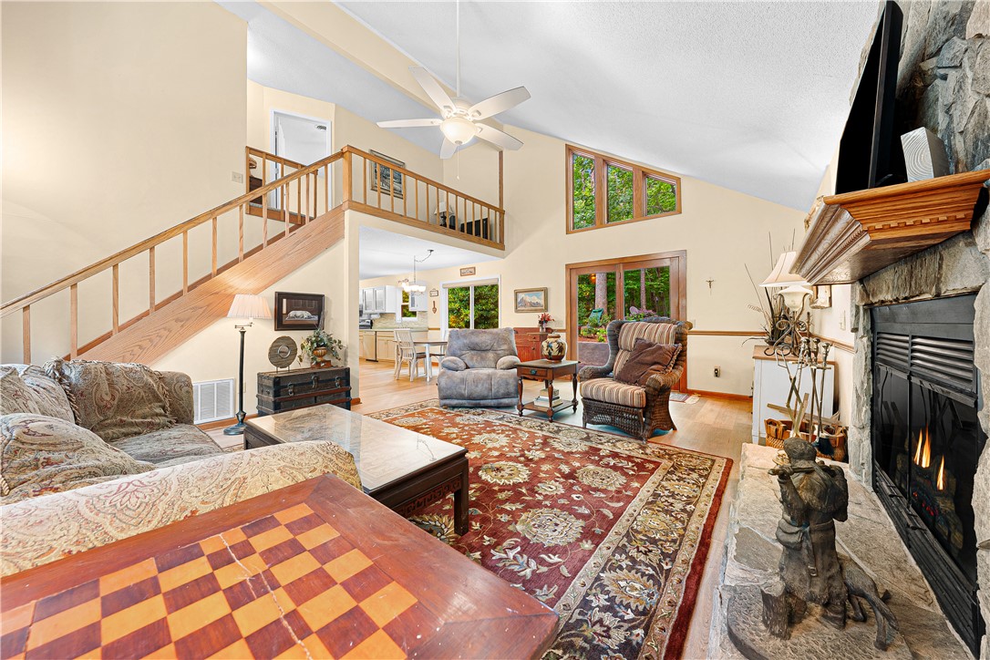 139 Tulip Lane Westminster, SC 29693 - Photo 6 of 37 A stone hearth anchors this welcoming living area, boasting a vaulted ceiling and a second-story overlook.