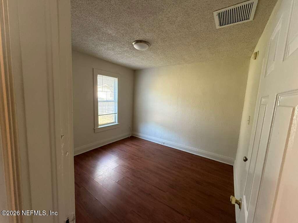 4067 Gilmore Street Jacksonville, FL 32205 - Photo 2 of 10 a view of an empty room with wooden floor and a window